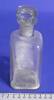 Clear glass bottle with glass stopper, tall, white powder, part of medicine chest [col.0013]