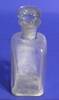 Clear glass bottle with glass stopper, tall, white powder, part of medicine chest [col.0013]