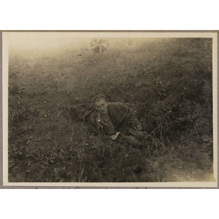 A wounded German abandoned by his comrades in a shell hole, waiting for stretcher-bearers who arrived soon after.
