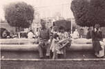 John Thomas (Jack) Harvey sitting on the edge of a fountain in Cairo. Some local children wanted to be in the photo too.
