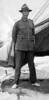 Portrait of Joseph Mahon (s/n 12/2373) standing outside a tent in his uniform and what looks light coloured slippers.