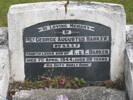 Concrete headstone with marble engraved plaque with large concrete surround covered with pebbles.