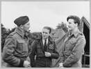 The bloke on the left in the first of these  photos is Flt Lt Lloyd George Mason NZ402028 DFC. He originated from Johnsonville in Wellington and joined the RNZAF in 1940 qualifying as a pilot later that year with the rank of Sergeant. He was transferred to the RAF in 1941 and joined 127 RAF Squadron flying Hurricanes in Iraq and North Africa. He later joined 33 RAF Squadron again flying Hurricanes and then later Spitfires in North Africa in what was termed an Army Close Support unit which was part of 2nd Tactical Air Force which was basically “flying artillery”. 33 Squadron would have been tasked with destroying gun emplacements, vehicles, communications literally anything that the Army normal artillery would struggle to hit. 
33 Squadron returned to the U.K. in 1944 in preparation for the D Day landings and during that time 33 Squadron was part of 135 Wing which was commanded Wing Commander Ray Harries who stands centre in the photo.
33 Squadron as part of 135 Wing at this time was un