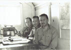 In the Pl. orderly room we packed up and painted cream while sitting between Sousse and Enfidaville waiting for Jerry t gasp his last in N. Africa. Matt Martin (a division Sgt. now Coy Q.M) Dick Betteridge (Pl canteen manager) + Jack Foster ( Clerk). At the end of the desk is one of theStie phones we used for communication inter Pt. &amp; Coy H.Q.