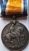 Round metal with name etched on side: 1914-1918. Horse with rider carrying a saber on one side. King Georg. on other side. 12359 PTE. P. DELAHUNT. N.Z.E.F. plus ribbon attached.