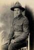 1st NZEF soldier in uniform, lemon squeezer hat and bayonet. Sitting in a chair.