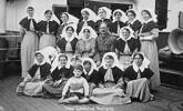 16 New Zealand nurses aboard the deck of the troopship R.M.S. &#39;Athenic&#39;, with one male army officer, and a small boy (in front row). As part of a fifth contingent of nursing staff, 25 nurses travelled on both the &#39;Athenic&#39; and &#39;Opawa&#39; to England, in 1916. Included in that contingent were Sisters Alice Haywood, E.F.Martin, E.Barnes, F.Hart, L.K.Scanlon, B.Watters, N.Mandeno, E.A.Parkinson, R.C.Makeig, N.Slater, E.E.Beattie, M.McGee, J.N.McGhie, A.C. McKerchar, S.G.Barr, I.C.Ancell, E.M.Fitzgerald, E.Beer, N.M.Jensen. [Note: it is not known which of these may be in this image]. The &#39;Athenic&#39; disembarked from Wellington, New Zealand on 30th December, 1916, carrying the troops of the 2nd Draft, 20th Reinforcements, New Zealand Expeditionary Force. 
30 Dec 1916 - Staff Nurse Stella Grace embarked on the ‘Athenic’ at Wellington