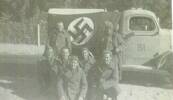 Soldiers pose in front of a Nazi truck