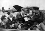 The Williamson crew present camembert cheeses to Bomb Aimer Graham Coull (centre), Martragny, France, 1/2 July 1944, on the occasion of his 22nd birthday. S/L Nick Williamson at right. On the 30th of June they had landed Lancaster ND917, JN-O (behind them) on a fighter landing strip very close to the front line in Normandy, the first ever Lancaster to land in liberated France.
- NZ Bomber Command Assn.