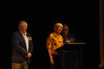 Norman Fry, Kath Newman and Mike Williams standing at the lecture. Kath Newman gives her speech.Kath Newman's speech:Thank you for inviting us and for telling the story of my husband, Phillip. And I’m so gratefulthat Mike Williams has come over from New Zealand. Phillip would have died in Vietnam if ithadn't been for Mike and Bill Papuni, John Adams, John Galley and Norman Fry.Sadly, Phillip never got to meet you to say thanks for saving his life. I know he spent yearswondering who those blokes from New Zealand were that pulled him from that tank andsaved his life.But today I get to say thank you. If it hadn’t been for your bravery, I would never have metmy husband, who was such an inspiration to many other people.