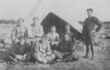 Quarantine Camp or "The happy family" (New Zealand) on 30 August 1915 before leaving for the war. In the photo (back row) T. Brent, D. Hartnett, C.H. Senior, A.G. Nell; (front row) Conway, T. Caskey, A.W. Heald. Standing to the right Eastwood. This may be T. Caskey but would need to be verified. - No known copyright restrictions