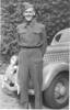 Lieutenant Horrocks in uniform standing beside car - This image may be subject to copyright