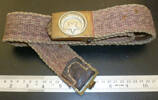 Woven Turkish military belt with embossed brass buckle and clasp. Photographs show leather reinforcement and stitching in underside of belt, and a leather tip covering the woven fabric. The belt belonged to a Turkish soldier captured as POW during the fighting at Gallipoli and the belt was brought back to New Zealand by this soldier. (held in private collections) - No known copyright restrictions