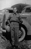 Bernard Arnold Bisphan leaning against vehicle - This image may be subject to copyright