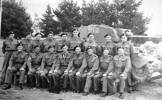 Group, men seated in front of tank. James Reginald Martin is in the front row, third from right. - This image may be subject to copyright
