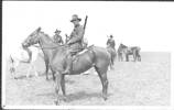 Men on a horses, [Anglo-Boer War] possibly Trooper Heasley on horseback in the foreground, horses and soldiers in the background (Heasley family album) - No known copyright restrictions