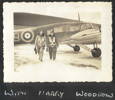 Airmen walking away from plane, carrying helmets, R.S. (Torchy) Moore (left) and Harry Woodrow (right). - This image may be subject to copyright