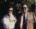 Portrait, Mr Hubert Crispin & Mrs Mary Crispin nee (Stapleton) standing outside in front of a tree, in later life, wearing medals. Annotated at back early 1980's at 36 Owen's Road, Epsom, Auckland - This image may be subject to copyright