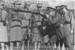 Rifle Drill instruction at the Drill Hall, Rutland Street, Auckland. Others in the photo are Jean Trust, M. Dale-Taylor (others not named). - This image may be subject to copyright