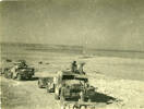 Desert, WW2, artillery convoy, soldiers on roof of vehicle, gun in foreground - This image may be subject to copyright