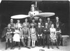 Geelong Air Service Pratt Bros. Group photo, workers and staff [?] seated on a wooden bench or standing in front of an aeroplane engine and propeller - No known copyright restrictions