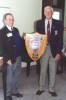 Veterans Murray Adlington with Ron Lamb holding a wooden commemorative shield. - This image may be subject to copyright