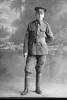 Full length portrait of Corporal Harold Percival Corlett, Reg No 12/3595, of the 3rd (Auckland) Regiment, Auckland Infantry Regiment, - A Company. (Photographer: Herman Schmidt, 1915). Sir George Grey Special Collections, Auckland Libraries, 31-C301A. No known copyright.