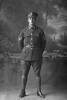 Full length portrait of Corporal Henry Archibald Basil Cruller, Reg No 31401, of the 19th Reinforcements, J Company. Killed in action in France on 12 October 1917 at the Battle of Passchendaele. (Photographer: Herman Schmidt, 1916). Sir George Grey Special Collections, Auckland Libraries, 31-C2258. No known copyright.