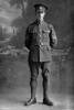 Full length portrait of Quartermaster Sergeant Arnold Edgar Mills, Reg No 13/3732, 3rd (Auckland) Regiment, Auckland Infantry Regiment, - A Company. Killed in action in France on 7 July 1916. (Photographer: Herman Schmidt, 1915|1916). Sir George Grey Special Collections, Auckland Libraries, 31-M814. No known copyright.
