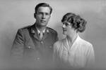 3/4 group portrait of Chaplain Captain Leslie Bourneman Neale, Reg No 35569, of the Chaplain Corps, and a woman, probably his wife Mary. (Photographer: Herman Schmidt, 1917). Sir George Grey Special Collections, Auckland Libraries, 31-N2890. No known copyright.