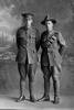 Full length portrait of 2 men, Hattaway and Granger, possibly Corporal Percival Granger (right), Reg No 18066, of the New Zealand Field Artillery (seated), and Trooper Harold Granger Hattaway, Reg No 40562, of the 24th Reinforcements, New Zealand Mounted Rifles (departed with the 23rd Reinforcements). (Photographer: Herman Schmidt, 1917). Sir George Grey Special Collections, Auckland Libraries, 31-H2293. No known copyright.