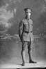 Full length portrait of Corporal Plyaro (?) of the Specialist Company. Possibly (Sergeant in the roll) Marcus George Pezaro, Reg No 46242, of the Specialist Company (Signal Section). Born in Australia. (Photographer: Herman Schmidt, 1917). Sir George Grey Special Collections, Auckland Libraries, 31-P3465. No known copyright.