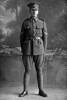 Full length portrait of Corporal George Ambrose Quinlan, Reg No 23314, of the 13th Reinforcements, 7th Reinforcements to the 1st Battalion, New Zealand Rifle Brigade, E Company. In the roll of Honour as a Lance Corporal with the Auckland Infantry Regiment. Killed in action in France on 26 March 1918. (Photographer: Herman Schmidt, 1916). Sir George Grey Special Collections, Auckland Libraries, 31-Q4587. No known copyright.