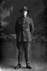 Full length portrait of Trooper Ronald Harris Trounson, Reg No 16135, of the 3rd (Auckland) Mounted Rifles, Auckland Mounted Rifles, New Zealand Mounted Rifles, 15th Reinforcements. (Photographer: Herman Schmidt, 1916). Sir George Grey Special Collections, Auckland Libraries, 31-T2549. No known copyright.