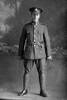 Full length portrait of Private Wood with the 15th Reinforcements, A Company. Probably Private Maurice Edmond Vernon Wood, Reg No 18882, of the Auckland Infantry Battalion. (Photographer: Herman Schmidt, 1916). Sir George Grey Special Collections, Auckland Libraries, 31-W1407. No known copyright.