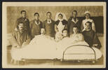 Unknown photographer (1917) What do you think of our happy family?. Group portrait of patients, nurses and orderlies on a ward. Three male patients are posed in two hospital beds, each bed has additional male patients sitting either side. Standing behind are two nurses and four male staff. Inscription on verso reads: "What do you think of our happy family? Room 12, Ward 2, Oatlands Park, Feb. 18th, 1917. Back Row - Mick Galoion, M.G.C; Lake Falconer, Ruskins boy, Charlie Coombes, 16th Waikato; Sister Miller; Burgess; Nurse Wilson. Front Row - Cpt. R. Colhoun, Tunnellers; H. Yates, 3rd Akd; Reeves Currie, 3rd 7. Arb(?); Sgt. Paddy Connell, Wgtn West Coast Ed Stern, Dio ...llers (?)." [sic]. Auckland War Memorial Museum call no. D570 M48 W241 p16. Image has no known copyright restrictions.
