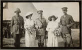 Black and white portrait of Captain Thomas Arnold Blake (centre) and Miss Mabel Constance Deane (2nd from left) with some members of their wedding party including Sister Dixon (2nd from right), Major Peter Maxwell Edgar (1st from left) and Lieutenant-Colonel Charles Ernest Randolph Mackesy (1st from right). Major Thomas A. Blake photograph album. Auckland War Memorial Museum - Tamaki Paenga Hira (PH-2014-69-1-p4-1). Image has no known copyright restrictions.
