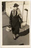 Unknown, photographer (ca. 1936). Edith Jane Austen.  Black and white snapshot of Edith Austen walking down an Auckland street. Austen is wearing a long dark coloured jacket and skirt, a hat, a fox stole and is carrying a parcel and a basket holding a small dog. Austen, E.J. (1900-1940). Edith Jane Austen Photographs. Auckland War Memorial Museum - Tamaki Paenga Hira. PH-2003-46-4. Image has no known copyright restrictions.