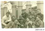 Group of Airmen on board S.S. Arawa, c. October 1917. Edwyn Arnold Fraser Wilding (CAC graduate no. 1) second from right at back, Ross Brodie (CAC graduate no. 9) directly in front of him and possibly Herbert Nelson Hawker (CAC graduate no. 2) to his right (wearing pilot badge). Ernest Taniwha Sutherland (CAC graduate no. 8 and the first M_ori graduate) fourth from left in front (with hat and camera). J. E. Stevens believed to be at extreme left (CAC graduate no. 3) and Clarence James McFadden (CAC graduate no. 4) second from right in front (in front of Brodie). The airmen were on their way from New Zealand to England to begin training with the Royal Flying Corps. From the Edwyn Wilding collection. Airforce Museum of New Zealand (AFM 2007/191.9). Image has no known copyright restrictions.
