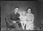 Serviceman Leslie Richard Lander seated with his young daughter and wife, Gwendoline Emily Lander. Leslie served in the Royal Air Force during World War Two (II). Photograph (ref: SW1944.2168) held by Puke Ariki Museum, New Plymouth, New Zealand : pukeariki.com - Please do not reproduce without permission from Puke Ariki. Contact images@pukeariki.com for more information.