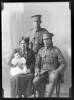 Studio portrait of a two men in military uniform, a woman and a baby. The man standing in military uniform is believed to be Joe Kotua. The man seated in military uniform is believed to be Pehiatea Akuhata (Percy August) Kotua who is thought to have been a fisherman in Nelson before World War One. These two men were brothers. The lady holding a baby is thought to be Sophia Ngahopi Kotua (nee Warena), the wife of Pehiatea Akuhata Kotua. The baby is thought to be "Joey" Ngamamae (Josephine) Kotua. Kotua. Nelson Provincial Museum, Tyree Studio Collection: 90020.