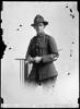 Crown Studios, Auckland. Studio portrait of a soldier who is holding a swagger stick. Hat badge displays two crossed flags and fern wreath denoting a Specialist Unit, M.G. (Machine Gunner). Name from glass plate inscription: E. Chambers. See also 7003-058. Auckland Libraries Heritage Collections 7003-019. No known copyright restrictions