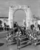 Womens Auxiliary Air Force drummers leading an ANZAC parade through the Bridge of Rememberance, Cashel Street, Christchurch. Alison Mclay, drum major in front. L-R: Front rank; Joan Chamberlain, Alma Goggin, Sheila Macdonald. Second rank; Fay Hammond, Hilda Walls, June McPhail. Third rank; Stella Ward, Peggy Sussems, Margaret Tisdall. Image kindly provided by the Air Force Museum of New Zealand, MUS02168.