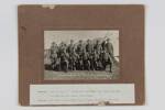 Tapawera Mounted Contingent in camp at Nelson in August 1914. The image shows twelve males, seven standing, five seated in front of them, all in military uniform. The print is mounted on brown card. The men are named below: Bracefield, Jack [Clure crossed out] [Clougher handwritten above], Rory Arnold, Bob Mead, Bert Pearless, Jack Hannen, Frank Kidson. Jack Tomlinson, Norm McPherson, Jo Thomas, Len Kinsett, Jack Crimp. [Not in the photo Stan Berryman [--] handwritten in.underneath]. Tapawera Mounted Contingent. 16 Aug 1914. Nelson Provincial Museum Collection: 282833.