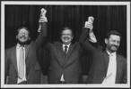Prime Minister David Lange holds up the hands of David Robinson and Reg Boorman in victory. Dominion Post (Newspaper): Photographic negatives and prints of the Evening Post and Dominion newspapers. Ref: EP-Politics-Labour Party 2-01. Alexander Turnbull Library, Wellington, New Zealand. /records/23248033