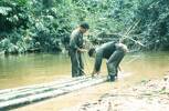 Ptes Dave Naera, Tony Frost 10 Pl "D" Coy making raft  Upper Temengger River. Image taken during Malayan Emergency 1959-1960. © Peter Gallacher.