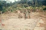 Staking down bamboo support on L-Z landing pad. A. McCutcheon (left), M. Maytum (kneeling). Image taken during Malayan Emergency 1959-1960. © Peter Gallacher.